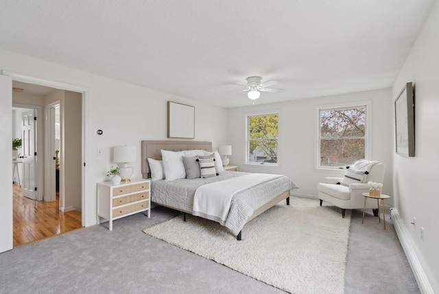 bedroom with carpet flooring, baseboard heating, baseboards, and ceiling fan