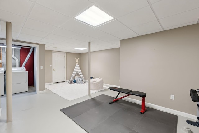 workout room with washer / dryer, a drop ceiling, and baseboards
