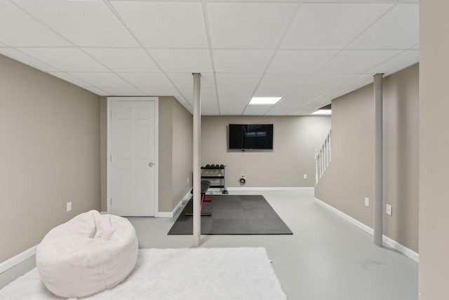 exercise room featuring a drop ceiling and baseboards