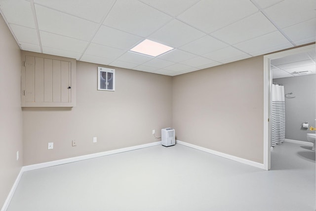 finished basement with a drop ceiling and baseboards