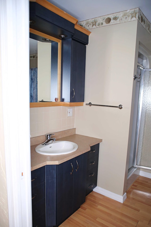 165 Pleasant Ave, Madawaska, ME 04756 - full bath with wood finished floors, baseboards, decorative backsplash, a shower stall, and vanity