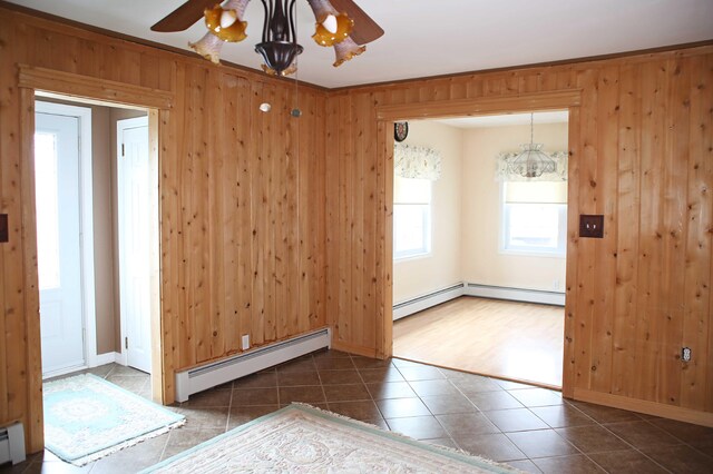 165 Pleasant Ave, Madawaska, ME 04756 - tiled spare room featuring a baseboard heating unit, ceiling fan, baseboard heating, wooden walls, and baseboards