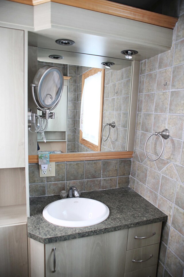 165 Pleasant Ave, Madawaska, ME 04756 - bathroom featuring backsplash, vanity, and tile walls