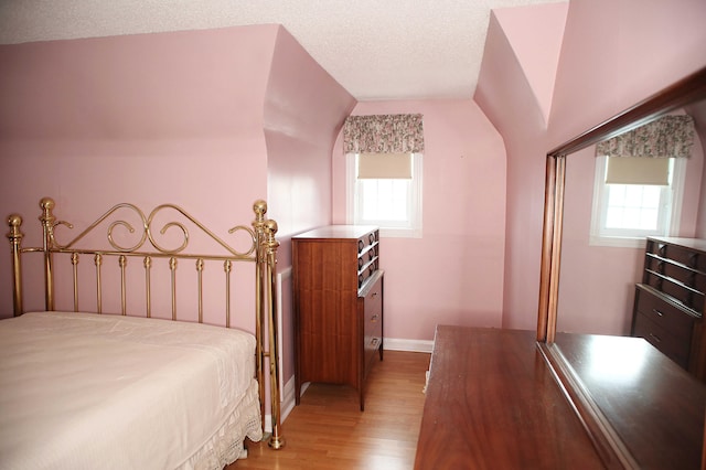 165 Pleasant Ave, Madawaska, ME 04756 - bedroom with multiple windows, light wood-type flooring, baseboards, and a textured ceiling
