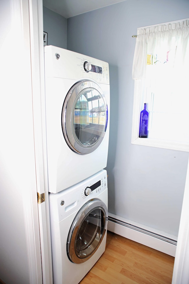 165 Pleasant Ave, Madawaska, ME 04756 - laundry room featuring baseboard heating, stacked washer / drying machine, and light wood-type flooring