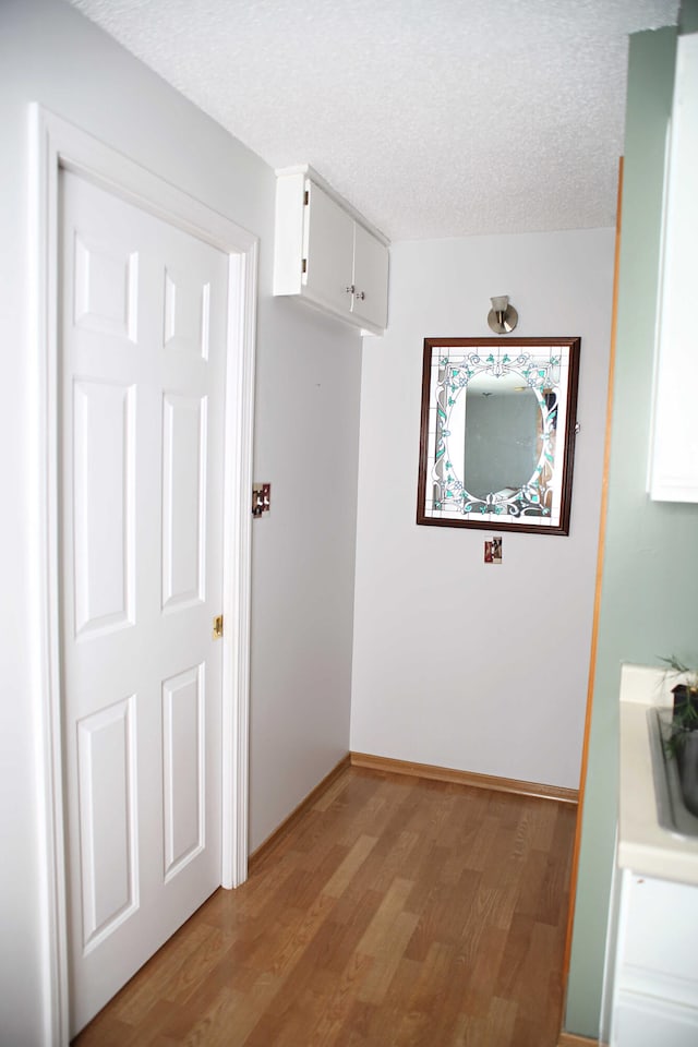 165 Pleasant Ave, Madawaska, ME 04756 - hall featuring light wood-style floors, a textured ceiling, a sink, and baseboards