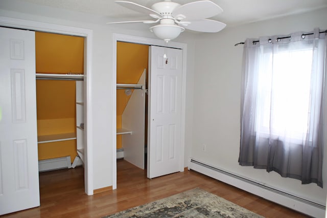165 Pleasant Ave, Madawaska, ME 04756 - unfurnished bedroom with baseboard heating, wood finished floors, and ceiling fan