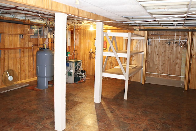 165 Pleasant Ave, Madawaska, ME 04756 - unfinished basement with a heating unit, wooden walls, and a water pressure tank