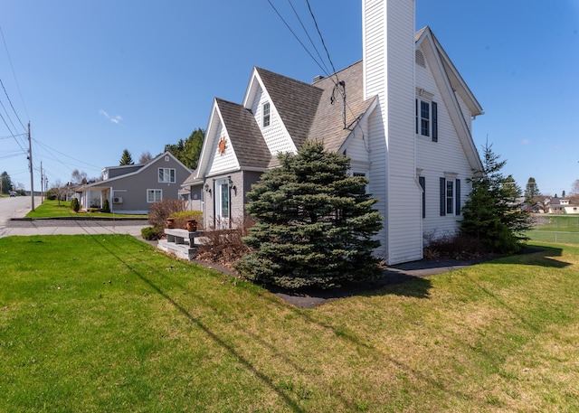 165 Pleasant Ave, Madawaska, ME 04756 - view of property exterior featuring a yard, roof with shingles, and a chimney