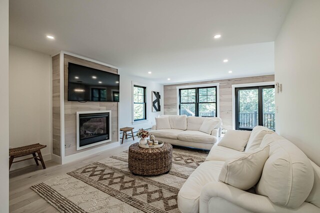 living room featuring wood finished floors, a fireplace, baseboards, and recessed lighting