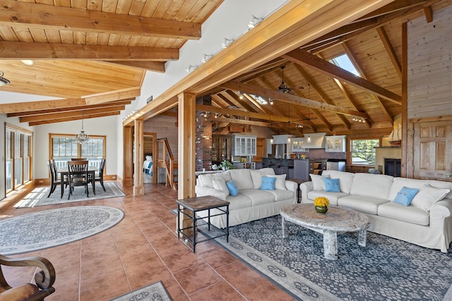 living room featuring vaulted ceiling with beams, tile patterned floors, a chandelier, and wooden ceiling