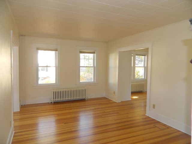 1 Prospect St, Sanford, ME 04083 - unfurnished room with light wood finished floors, baseboards, and radiator