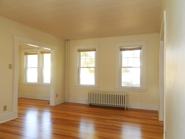1 Prospect St, Sanford, ME 04083 - empty room featuring baseboards, radiator, and wood finished floors