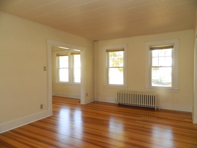 1 Prospect St, Sanford, ME 04083 - empty room featuring radiator, light wood finished floors, baseboards, and plenty of natural light