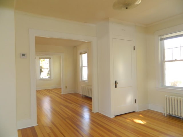 1 Prospect St, Sanford, ME 04083 - unfurnished room with light wood-style floors, baseboards, crown molding, and radiator