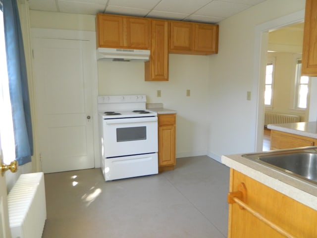 1 Prospect St, Sanford, ME 04083 - kitchen with under cabinet range hood, electric stove, light countertops, and radiator