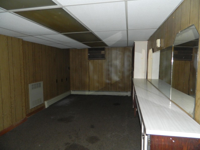 1 Prospect St, Sanford, ME 04083 - finished below grade area with dark colored carpet, a wall mounted air conditioner, wood walls, a drop ceiling, and a baseboard heating unit