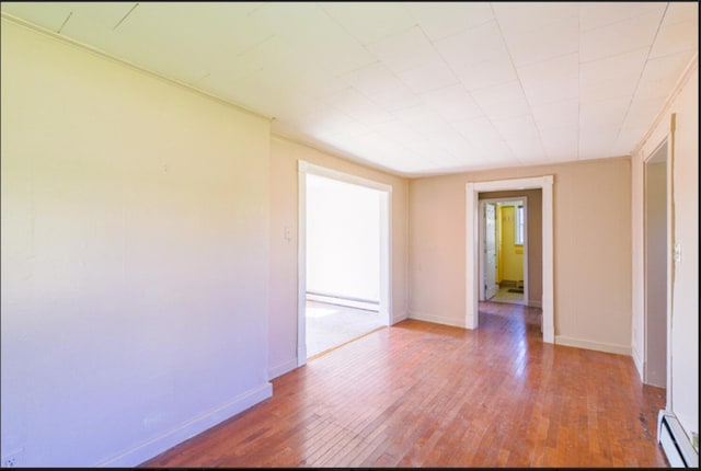 21 Exeter Rd, Corinna, ME 04928 - unfurnished room featuring baseboards, hardwood / wood-style flooring, and a baseboard heating unit