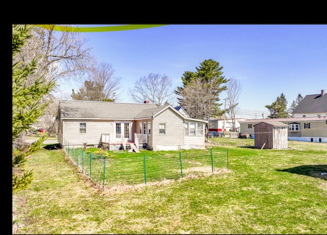 21 Exeter Rd, Corinna, ME 04928 - back of property with fence, a storage unit, a yard, and an outdoor structure