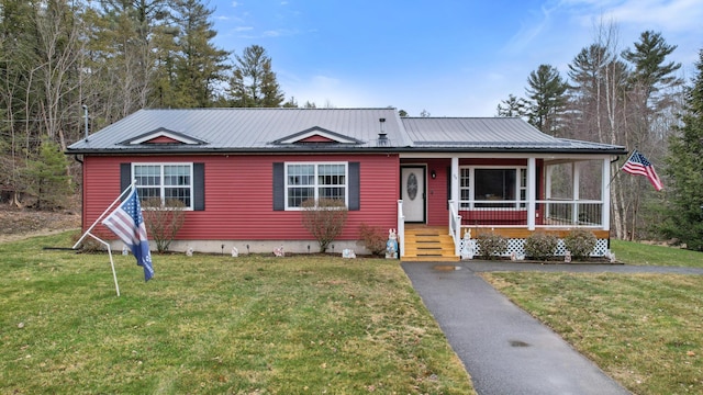 view of front of home with a porch, a front lawn, and metal roof