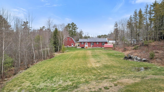 view of yard featuring a view of trees and a wooden deck