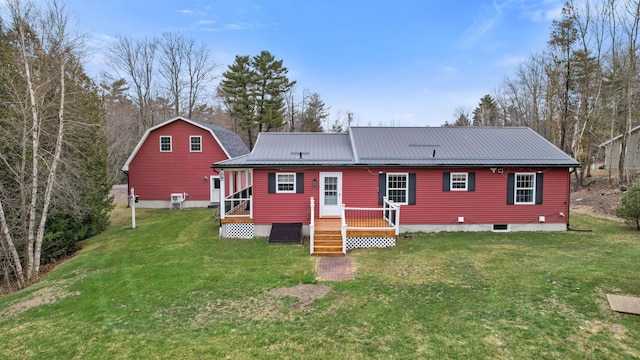 back of property featuring metal roof and a lawn