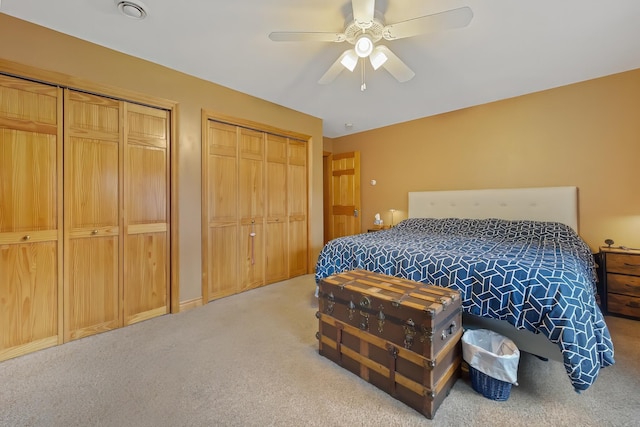 bedroom featuring carpet, two closets, and ceiling fan
