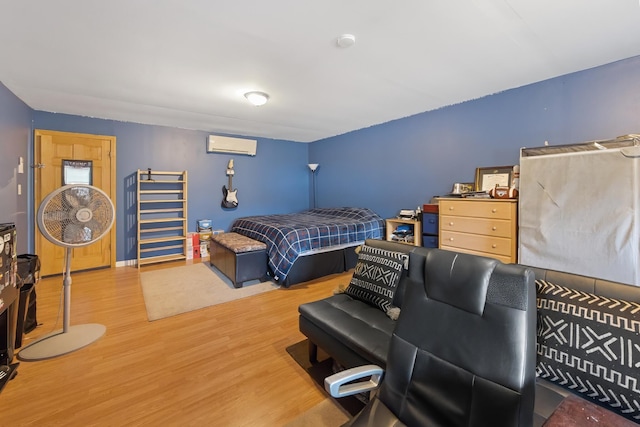 bedroom with a wall unit AC and wood finished floors
