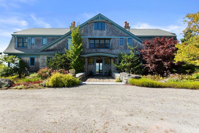 shingle-style home featuring a chimney and french doors