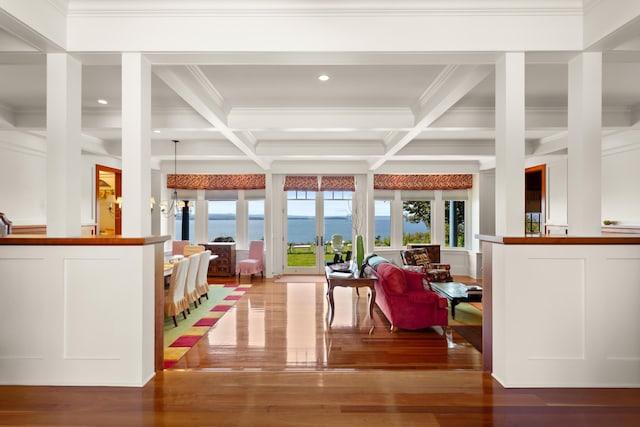 interior space with a water view, coffered ceiling, beamed ceiling, and a wealth of natural light