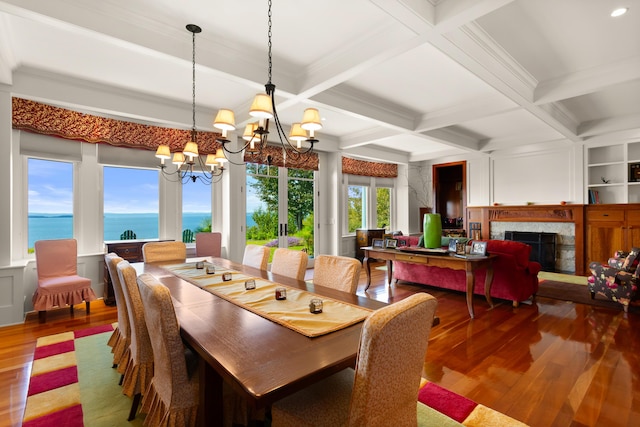 dining room with a chandelier, coffered ceiling, beamed ceiling, wood finished floors, and a fireplace