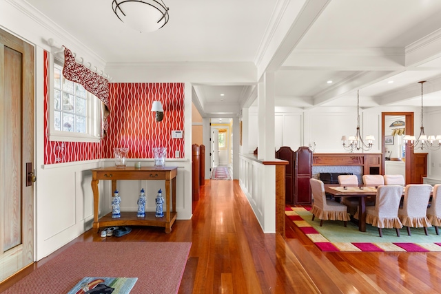 hallway featuring an inviting chandelier, a decorative wall, and a healthy amount of sunlight