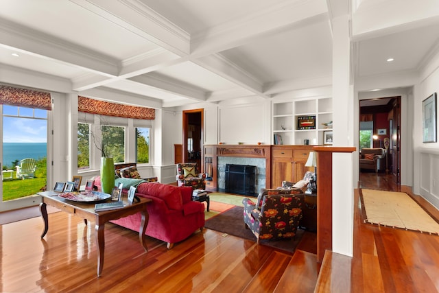 living room with wood finished floors, ornamental molding, and a healthy amount of sunlight