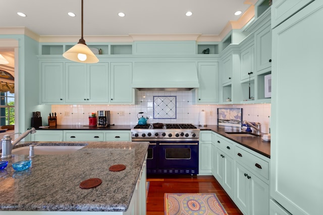 kitchen featuring premium range hood, dark wood-style flooring, a sink, and range with two ovens