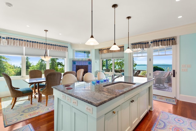 kitchen featuring dark stone countertops, dark wood-style floors, a wealth of natural light, and a sink