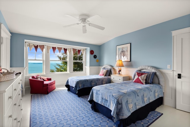 bedroom featuring a wainscoted wall and ceiling fan