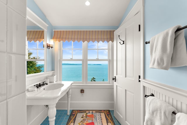 bathroom featuring a wainscoted wall and a water view