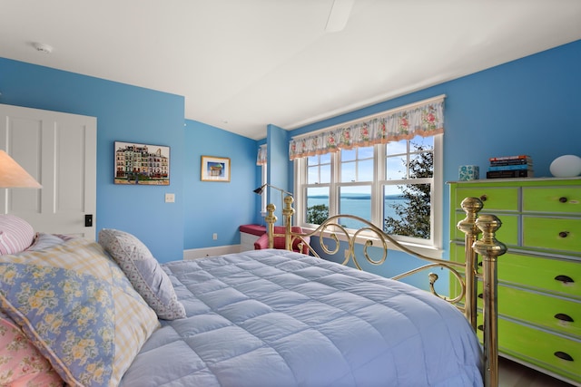 bedroom with lofted ceiling and baseboards