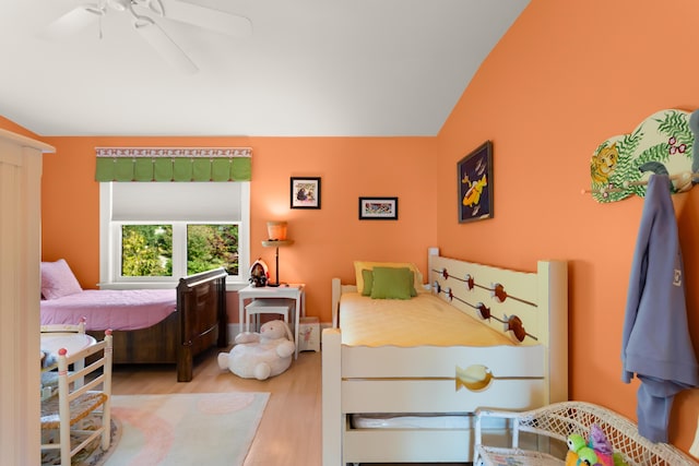 bedroom featuring lofted ceiling, a ceiling fan, and wood finished floors
