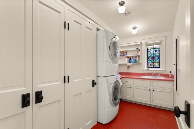 washroom with stacked washer and dryer, a sink, and cabinet space