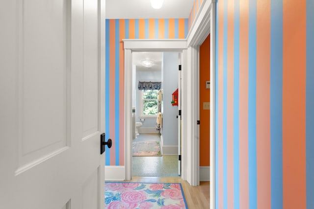 corridor with baseboards and wallpapered walls