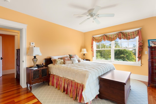 bedroom featuring light wood-type flooring, a ceiling fan, and baseboards