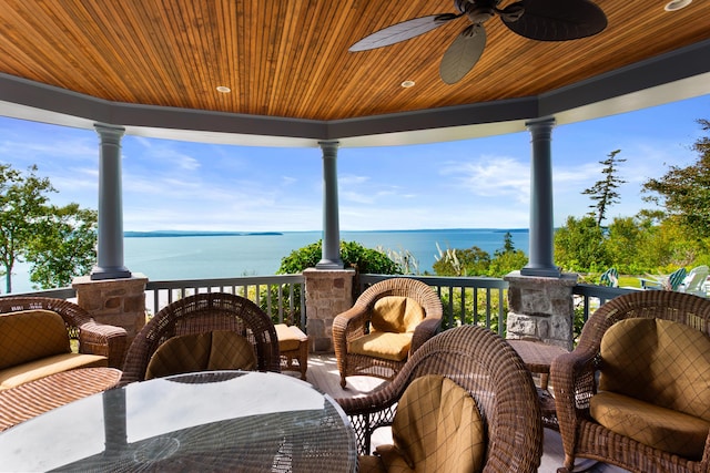 exterior space featuring ceiling fan and a water view