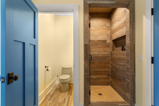 full bath with wood finished floors, a shower stall, and toilet