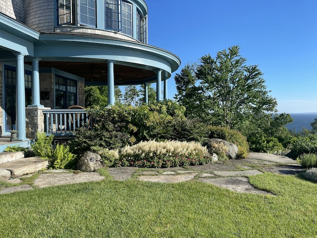 view of yard with a porch and a ceiling fan
