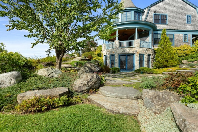 view of yard with a balcony and french doors