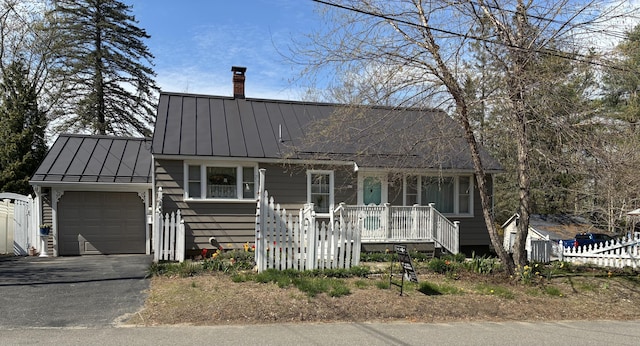 57 Salmond St, Belfast, ME 04915 - view of front of house with a standing seam roof, a garage, a chimney, driveway, and fence