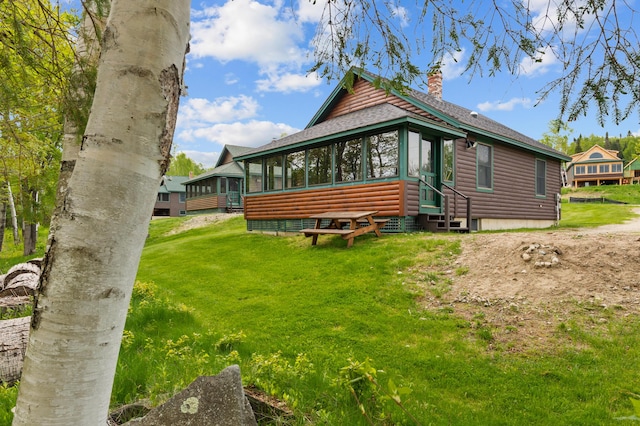 747 S Shore Dr Unit 6, Rangeley Plt, ME 04970 - view of property exterior with faux log siding, a chimney, a sunroom, roof with shingles, and a yard
