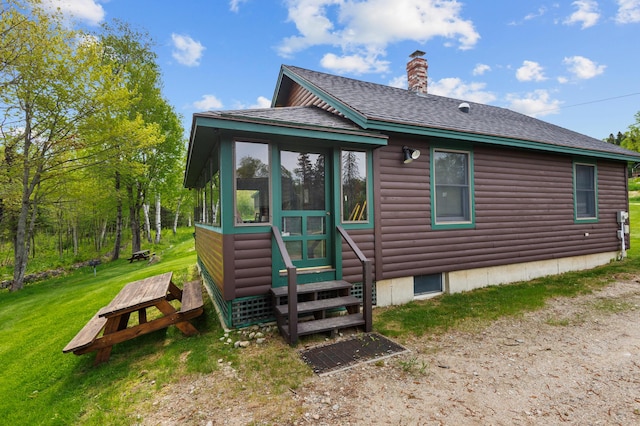 747 S Shore Dr Unit 6, Rangeley Plt, ME 04970 - rear view of house featuring faux log siding, entry steps, a chimney, a yard, and a shingled roof