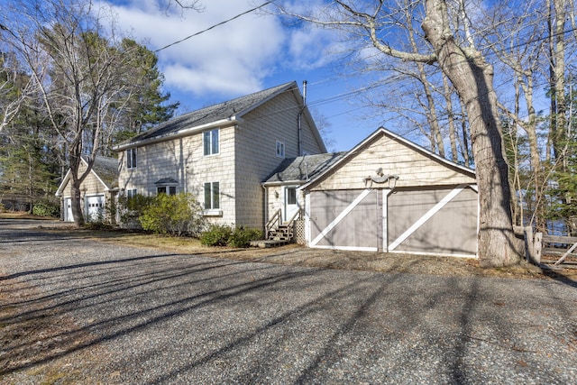 view of property exterior featuring a garage, entry steps, and aphalt driveway